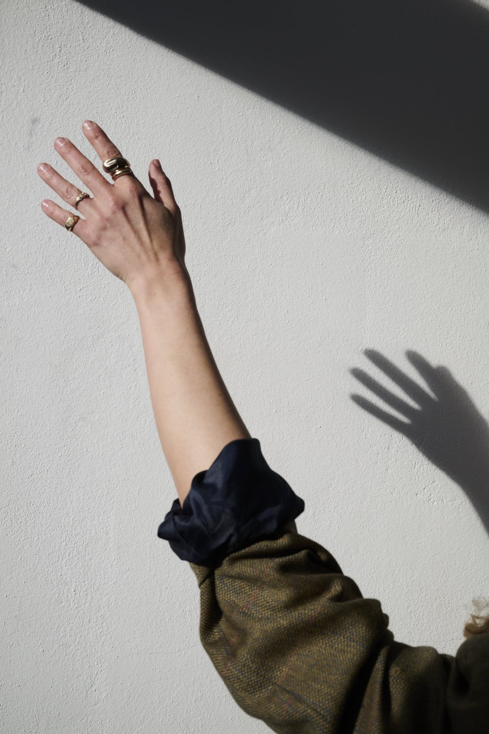 Arm vor heller Wand mit Schatten